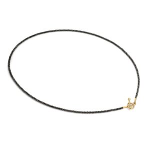 Een collier van zwarte spinel edelsteen en een gouden sluiting.