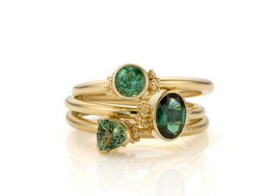 Set van losse Elevance ringen in geelgoud met groene edelstenen in verschillende slijpvormen en granules